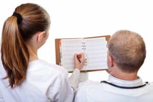 Doctor and lady holding a diary that she is writing in